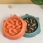 Two pet bowls, one orange and one teal, with textured surfaces on a white background.