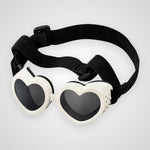 Heart-shaped shield glasses with white frames, dark lenses, and an adjustable black elastic strap, shown on a light gray background.